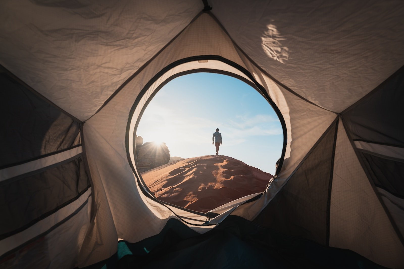 a man standing in a tent looking out into the distance